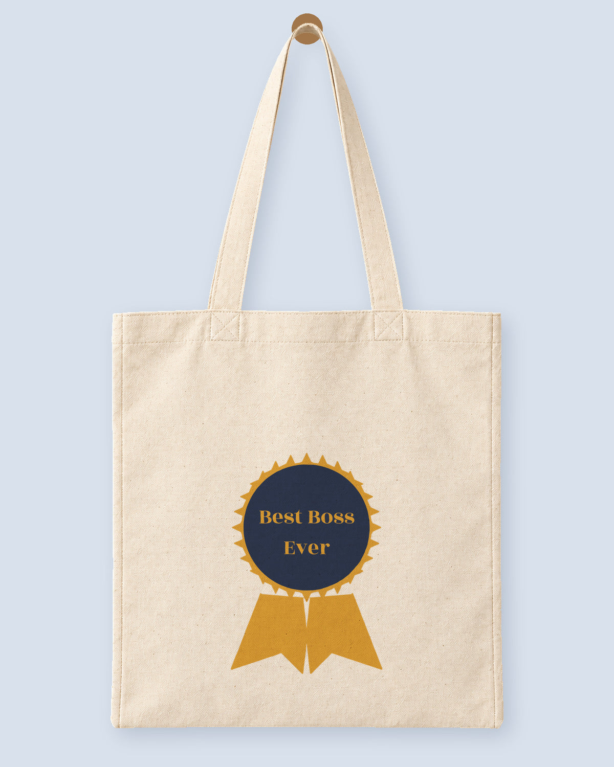 Natural canvas tote printed with “Best Boss Ever”, hanging on a wooden peg.