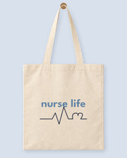Natural canvas tote printed with “nurse life”, hanging on a wooden peg.
