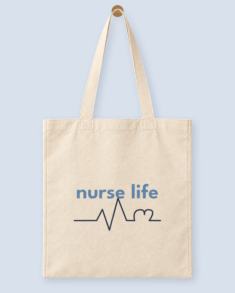 Natural canvas tote printed with “nurse life”, hanging on a wooden peg.