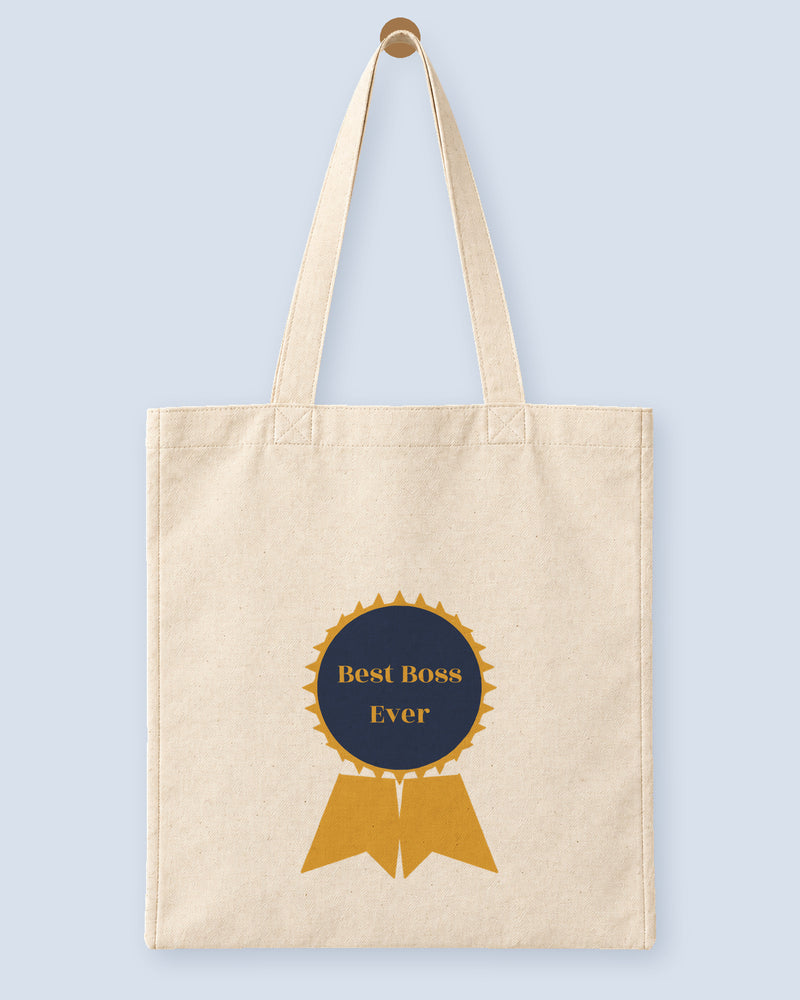 Natural canvas tote printed with “Best Boss Ever”, hanging on a wooden peg.