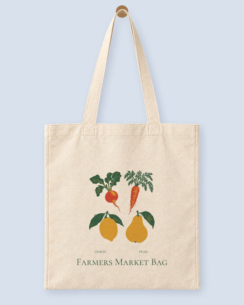 Natural canvas tote printed with “Farmers Market Bag”, hanging on a wooden peg.